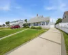Light-colored siding exterior with a pitched roof, featuring a multi-segment concrete driveway with paver accents leading to a detached garage Light-colored siding exterior with a pitched roof, featuring a multi-segment concrete driveway with paver accents leading to a detached garage