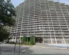 High-rise residential building featuring a terraced facade, individual balconies, brick exterior accents, and a covered entrance High-rise residential building featuring a terraced facade, individual balconies, brick exterior accents, and a covered entrance