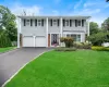 Split-level residence featuring light gray siding with brick accents and white trim Split-level residence featuring light gray siding with brick accents and white trim