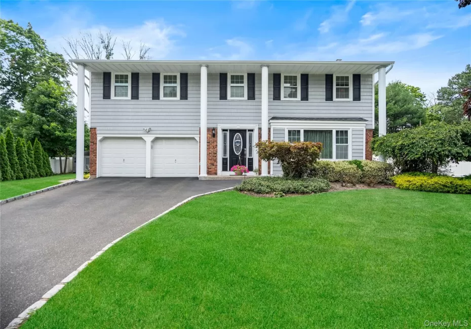 Split-level residence featuring light gray siding with brick accents and white trim Split-level residence featuring light gray siding with brick accents and white trim