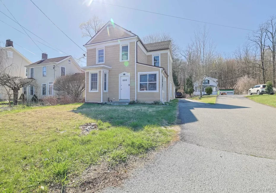 Traditional home with a front lawn and aphalt driveway Traditional home with a front lawn and aphalt driveway