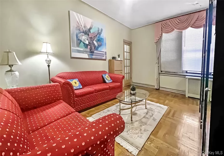Living room with a baseboard radiator, light parquet flooring, and radiator Living room with a baseboard radiator, light parquet flooring, and radiator