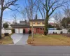 Traditional-style home featuring concrete driveway, a porch, brick siding, a garage, and a chimney Traditional-style home featuring concrete driveway, a porch, brick siding, a garage, and a chimney