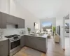 Kitchen with modern cabinets, a sink, a peninsula, light countertops, and stainless steel range with gas stovetop Kitchen with modern cabinets, a sink, a peninsula, light countertops, and stainless steel range with gas stovetop