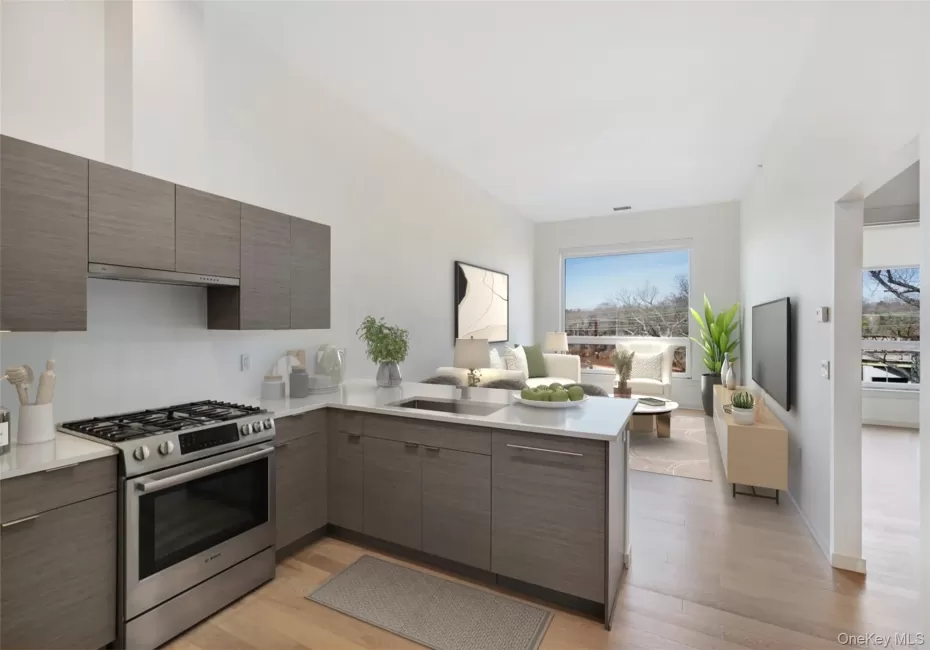 Kitchen with modern cabinets, a sink, a peninsula, light countertops, and stainless steel range with gas stovetop Kitchen with modern cabinets, a sink, a peninsula, light countertops, and stainless steel range with gas stovetop