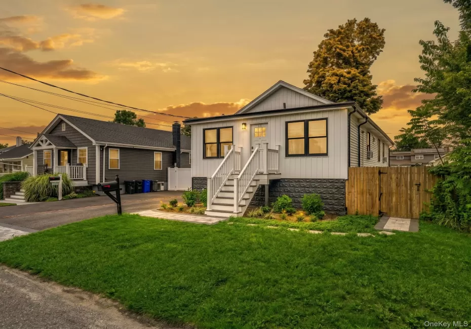 Exterior featuring white horizontal siding with a black horizontal siding accent, black-framed windows, and a white front entry door Exterior featuring white horizontal siding with a black horizontal siding accent, black-framed windows, and a white front entry door