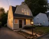 Gambrel-style residence featuring neutral siding and dark shutters Gambrel-style residence featuring neutral siding and dark shutters