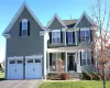 Traditional-style home featuring a porch, an attached 2 car garage, driveway, and a front yard Traditional-style home featuring a porch, an attached 2 car garage, driveway, and a front yard
