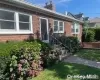 Doorway to property with brick siding, a chimney, and a yard Doorway to property with brick siding, a chimney, and a yard