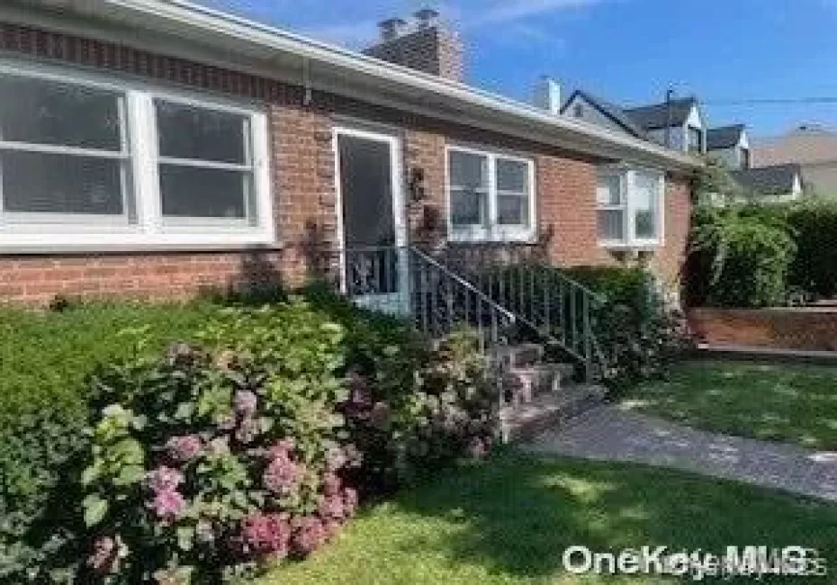 Doorway to property with brick siding, a chimney, and a yard Doorway to property with brick siding, a chimney, and a yard