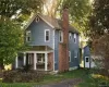 View of front of home with a chimney, covered porch, a garage View of front of home with a chimney, covered porch, a garage