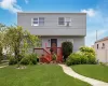 Two-story residence featuring light gray siding and a red-stained wood deck Two-story residence featuring light gray siding and a red-stained wood deck