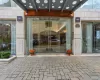 Modern building entrance featuring a stone-clad facade and automatic glass doors Modern building entrance featuring a stone-clad facade and automatic glass doors