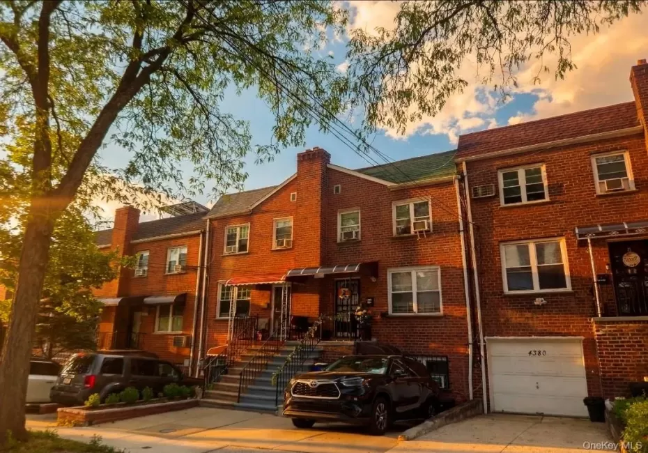 Brick facade residence featuring multiple windows, a front porch with an awning, and a private driveway Brick facade residence featuring multiple windows, a front porch with an awning, and a private driveway