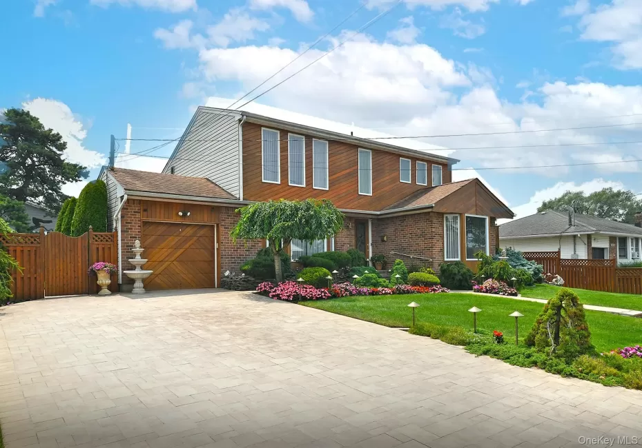 Two-story residence featuring a brick and wood-paneled facade Two-story residence featuring a brick and wood-paneled facade