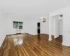 Unfurnished living room featuring radiator heating unit, a chandelier, and dark hardwood / wood-style flooring Unfurnished living room featuring radiator heating unit, a chandelier, and dark hardwood / wood-style flooring