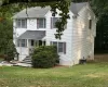 View of front of home featuring a shingled roof, a porch, and a front yard View of front of home featuring a shingled roof, a porch, and a front yard