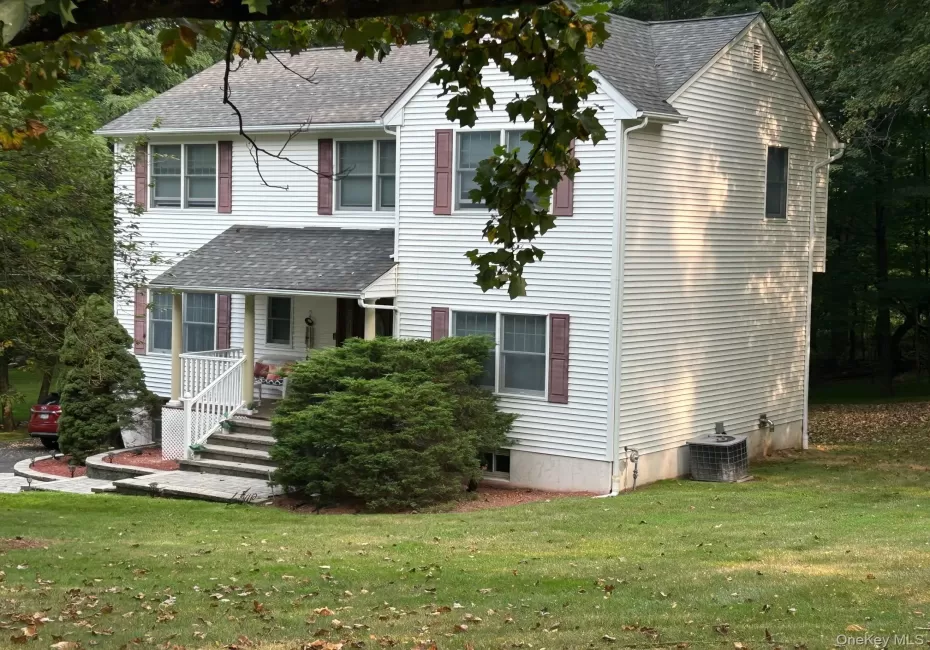 View of front of home featuring a shingled roof, a porch, and a front yard View of front of home featuring a shingled roof, a porch, and a front yard
