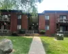 Brick facade building with multiple balconies and a central entrance featuring a large glass panel Brick facade building with multiple balconies and a central entrance featuring a large glass panel
