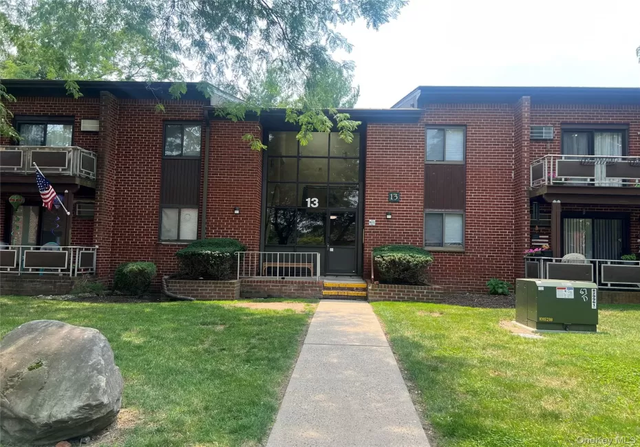 Brick facade building with multiple balconies and a central entrance featuring a large glass panel Brick facade building with multiple balconies and a central entrance featuring a large glass panel