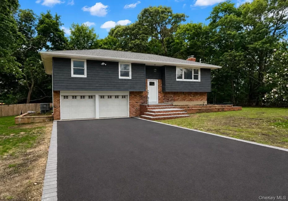 Split-level residence featuring a brick and dark gray siding exterior Split-level residence featuring a brick and dark gray siding exterior