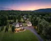 Spacious property featuring a two-story residence with a detached three-car garage, extensive paved driveway, and mature landscaping Spacious property featuring a two-story residence with a detached three-car garage, extensive paved driveway, and mature landscaping
