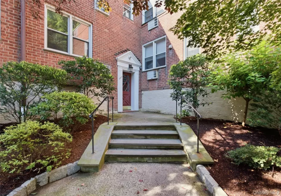 Brick facade building entrance featuring a red paneled door with a transom window Brick facade building entrance featuring a red paneled door with a transom window