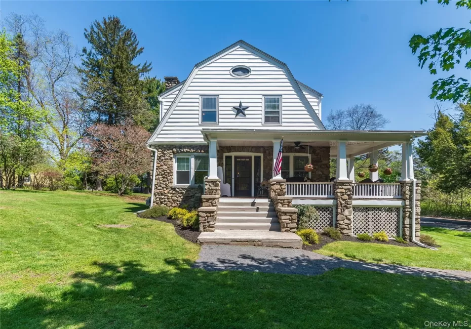 A picturesque 1930s residence featuring a stone porch that serves as a cool, shaded sanctuary. A picturesque 1930s residence featuring a stone porch that serves as a cool, shaded sanctuary.
