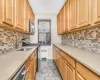 Kitchen featuring appliances with stainless steel finishes, decorative backsplash, radiator heating unit, and light stone counters Kitchen featuring appliances with stainless steel finishes, decorative backsplash, radiator heating unit, and light stone counters