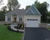 Craftsman house with asphalt driveway, stone siding, a front lawn, a shingled roof, and a garage Craftsman house with asphalt driveway, stone siding, a front lawn, a shingled roof, and a garage