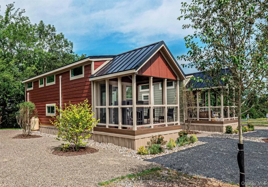 The Warwick Model. View of home's exterior with a metal roof, a standing seam roof, and covered porch The Warwick Model. View of home's exterior with a metal roof, a standing seam roof, and covered porch