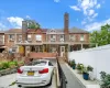 Brick exterior townhouse featuring a covered front entry, an attached garage, a paved driveway, a side walkway, and a privacy fence Brick exterior townhouse featuring a covered front entry, an attached garage, a paved driveway, a side walkway, and a privacy fence
