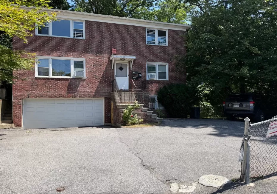 Brick facade residence with a two-story layout, featuring multiple windows and a front entry stairway Brick facade residence with a two-story layout, featuring multiple windows and a front entry stairway