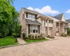 END UNIT Brick facade residence featuring a paver driveway, manicured landscaping, a paved walkway, and a decorative lamppost END UNIT Brick facade residence featuring a paver driveway, manicured landscaping, a paved walkway, and a decorative lamppost