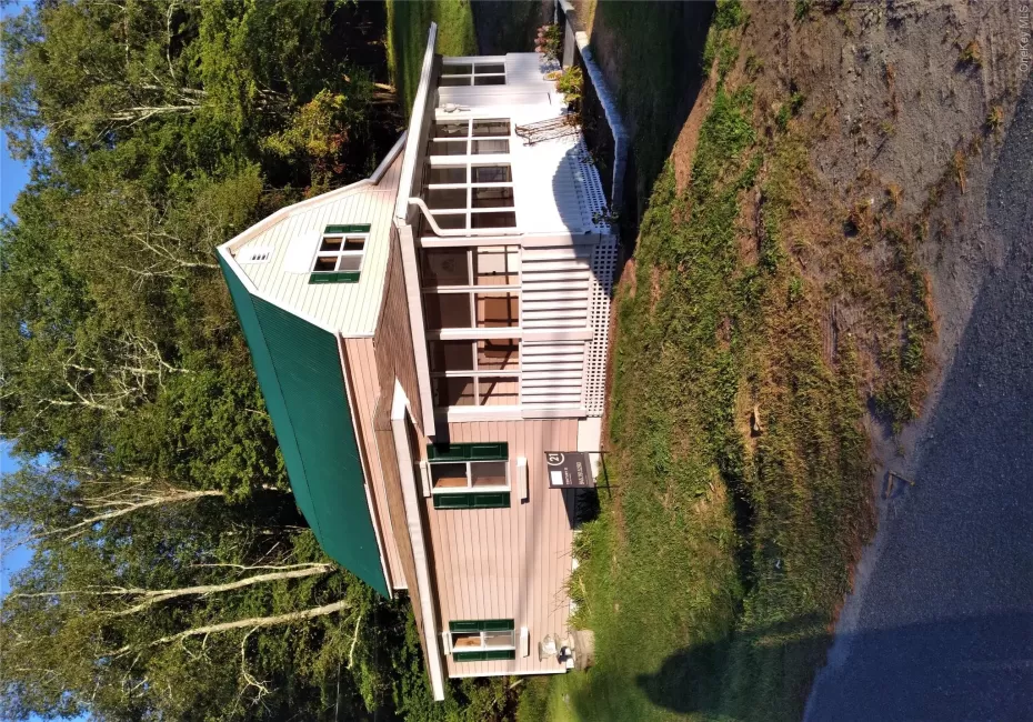 View of front of house with a porch, a gambrel roof, a front lawn, and a metal roof View of front of house with a porch, a gambrel roof, a front lawn, and a metal roof