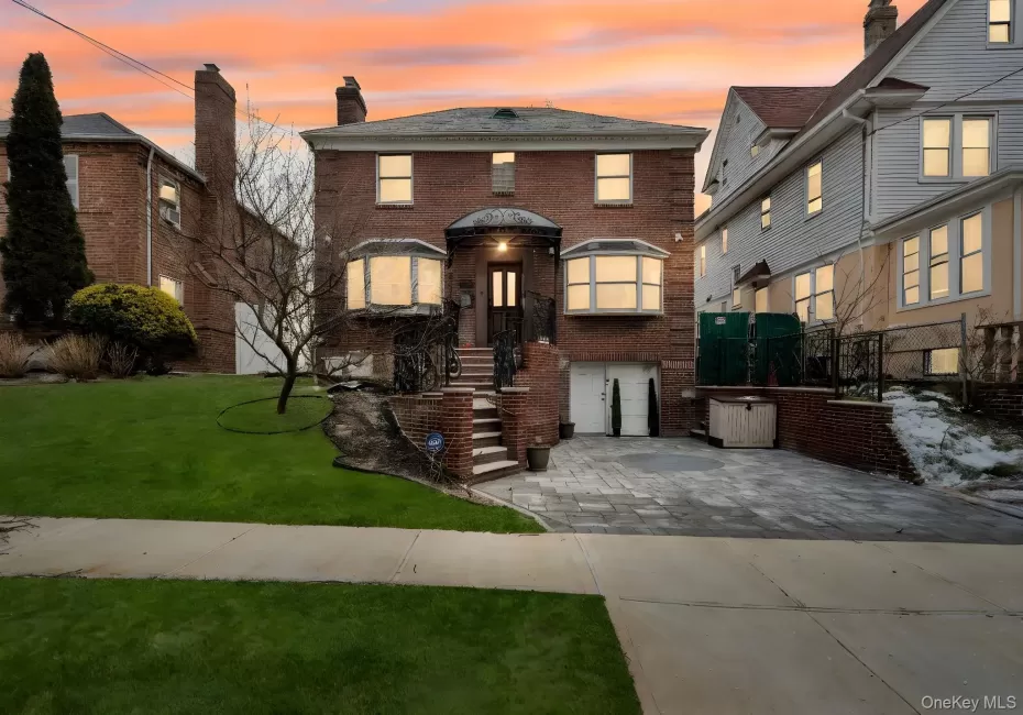View of front of home with brick siding, driveway, and a chimney View of front of home with brick siding, driveway, and a chimney