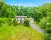 Two-story residence with a two-car garage, long asphalt driveway, and expansive lawn Two-story residence with a two-car garage, long asphalt driveway, and expansive lawn