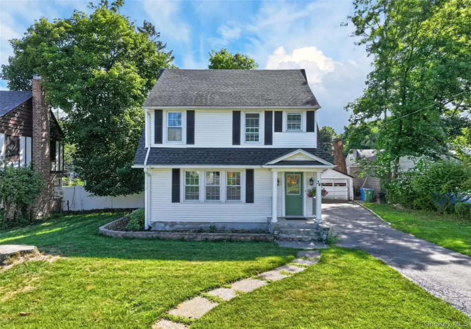 Two-story colonial-style residence featuring white siding, dark shutters, and a covered entryway Two-story colonial-style residence featuring white siding, dark shutters, and a covered entryway