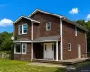 Two-story residence featuring cedar shake siding, a bay window, and a covered entry porch ( Ai enhanced) Two-story residence featuring cedar shake siding, a bay window, and a covered entry porch ( Ai enhanced)