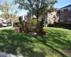 Brick monument sign with carved lettering surrounded by mature landscaping and seasonal plantings Brick monument sign with carved lettering surrounded by mature landscaping and seasonal plantings