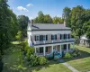 View of front of property featuring a front yard, brick siding, a porch, and a chimney View of front of property featuring a front yard, brick siding, a porch, and a chimney