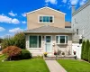 Colonial featuring light-toned horizontal siding and a gabled roof Colonial featuring light-toned horizontal siding and a gabled roof