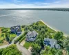 Waterfront property featuring extensive shoreline access, a private beach, and lush green landscaping Waterfront property featuring extensive shoreline access, a private beach, and lush green landscaping