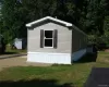 View of side of property featuring a storage unit, an outbuilding, and a yard View of side of property featuring a storage unit, an outbuilding, and a yard