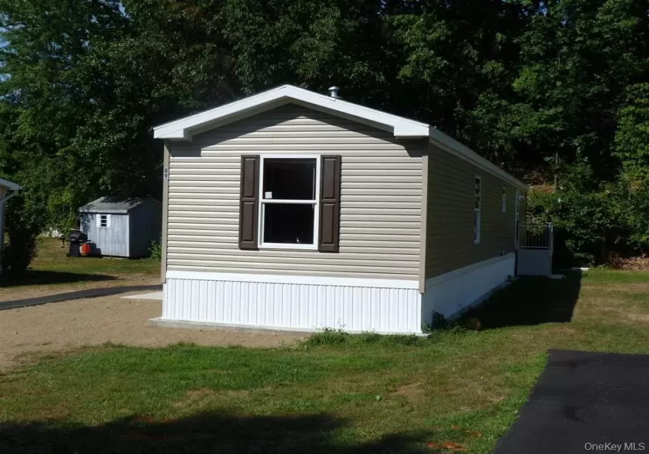View of side of property featuring a storage unit, an outbuilding, and a yard View of side of property featuring a storage unit, an outbuilding, and a yard