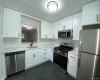 Beautifully renovated kitchen featuring white shaker cabinetry, quartz countertops, subway tile backsplash, stainless steel appliances and a ceramic tile floor Beautifully renovated kitchen featuring white shaker cabinetry, quartz countertops, subway tile backsplash, stainless steel appliances and a ceramic tile floor