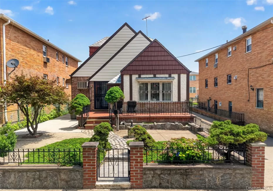 Tudor-style residence with a distinct gabled roofline and a brick and stucco exterior Tudor-style residence with a distinct gabled roofline and a brick and stucco exterior