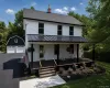 White siding exterior with a dark-paneled roof and covered front porch White siding exterior with a dark-paneled roof and covered front porch