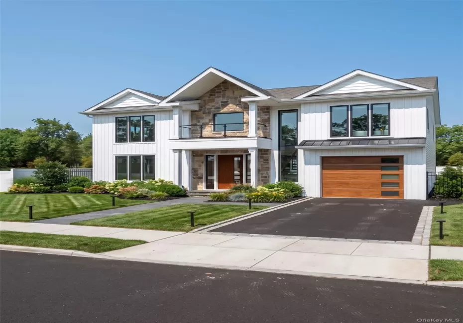 Contemporary residential exterior featuring white vertical siding and stone accents Contemporary residential exterior featuring white vertical siding and stone accents