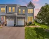 Contemporary townhome exterior featuring light gray siding and stone accents Contemporary townhome exterior featuring light gray siding and stone accents